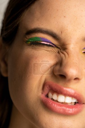 Photo for Cropped view of teenage girl with bright visage grimacing isolated on grey - Royalty Free Image