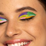 Close up view of happy teen girl with creative makeup closing eyes