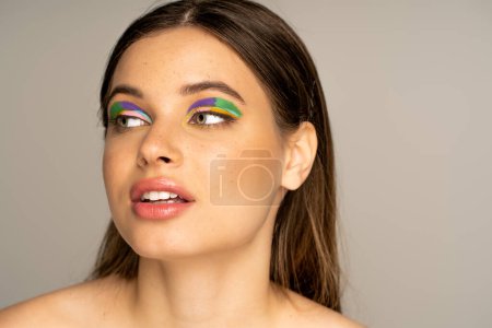 Téléchargez les photos : Teen model with colorful eyeshadows looking away isolated on grey - en image libre de droit