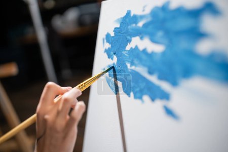 Téléchargez les photos : Cropped view of artist painting on canvas in workshop - en image libre de droit