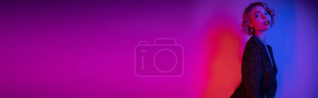 Photo for Young woman with blonde hair posing in black tight dress on purple and pink, banner - Royalty Free Image