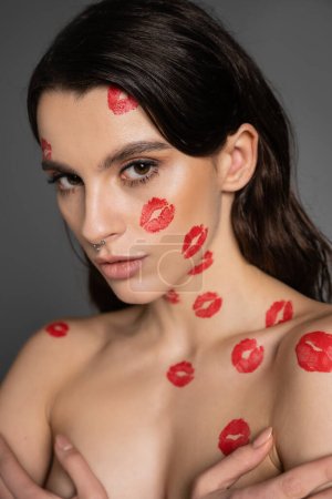 Foto de Portrait of sexy shirtless woman with red lipstick marks looking at camera isolated on grey - Imagen libre de derechos