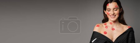 Photo for Pleased woman with red lipstick marks on face and body posing with closed eyes isolated on grey, banner - Royalty Free Image