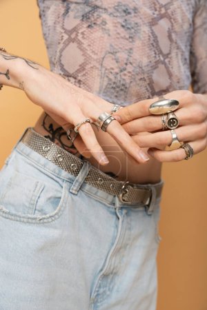 Cropped view of queer person touching rings on fingers isolated on yellow  tote bag #636814548