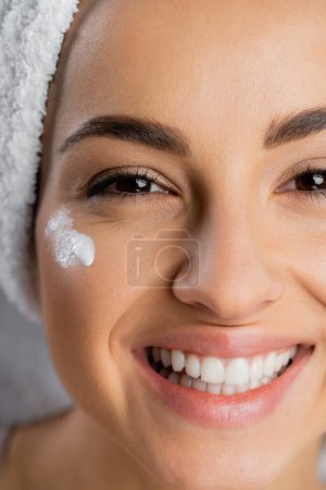 Photo for Close up view of woman with perfect skin and cream on face looking at camera isolated on grey - Royalty Free Image