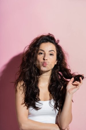 Foto de Young freckled woman pouting lips on pink background - Imagen libre de derechos