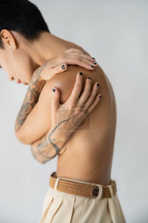 Photo for Partial view of shirtless woman covering breast while hugging herself isolated on grey - Royalty Free Image