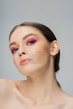 Photo for Portrait of charming woman with makeup and bare shoulders looking at camera isolated on grey - Royalty Free Image
