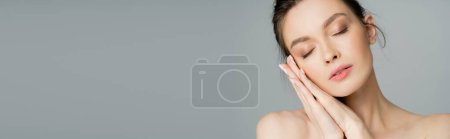 Young model posing with closed eyes isolated on grey, banner 