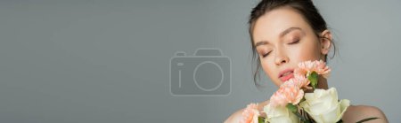 Pretty fair haired woman holding flowers isolated on grey, banner 