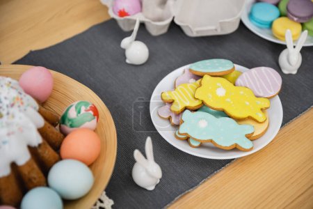 High angle view of Easter cookies and eggs near decor on table 
