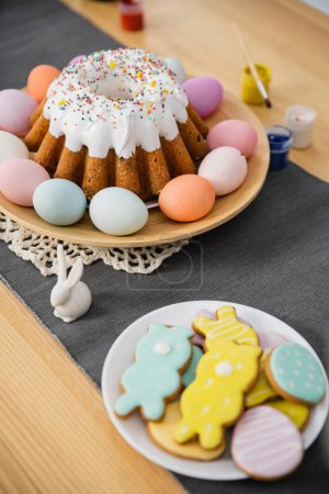 High angle view of sweet cookies and Easter cake on table 
