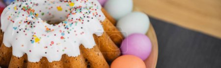 Leckeres Osterbrot und bemalte pastellfarbene Eier auf dem Tisch, Banner 