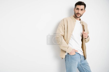 Foto de Hombre en ropa casual y jeans posando sobre fondo blanco - Imagen libre de derechos