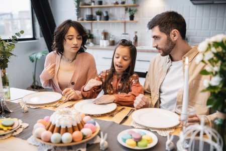 Fille parler près des parents pendant le dîner de Pâques à la maison 