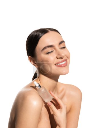 happy young woman with bare shoulders and closed eyes holding bottle with moisturizing serum isolated on white  Poster 642937252