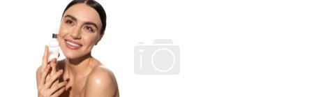 positive young woman with natural makeup holding bottle with serum isolated on white, banner 