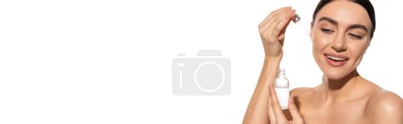 happy young woman with bare shoulders holding pipette with vitamin c serum isolated on white, banner  tote bag #642937344