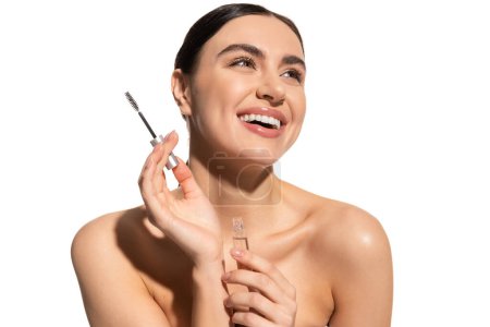 Téléchargez les photos : Happy brunette woman holding eyebrow brush and styling gel isolated on white - en image libre de droit