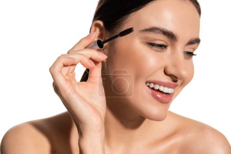 happy brunette woman holding eyebrow brush and smiling isolated on white 