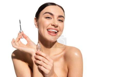 Foto de Mujer alegre sosteniendo el cepillo de cejas y el gel de peinado mientras que sobresale la lengua aislada en blanco - Imagen libre de derechos