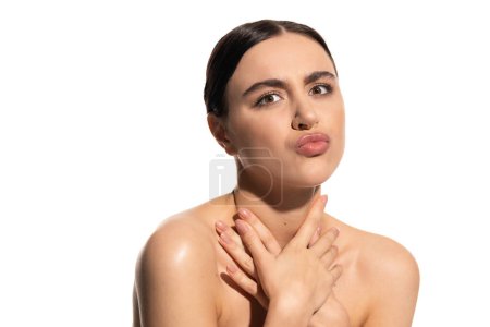 brünette Frau mit nackten Schultern und natürlich makellosem Make-up schmollen Lippen isoliert auf weiß 