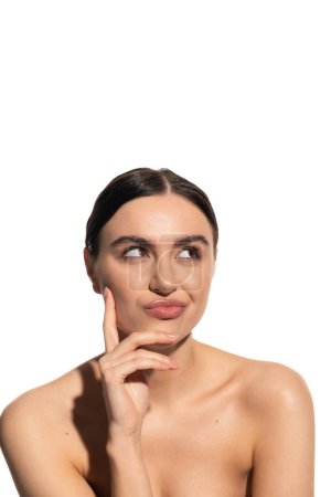 Foto de Mujer reflexiva con hombros desnudos y maquillaje natural pucheros labios aislados en blanco - Imagen libre de derechos