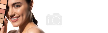 Photo for Positive young woman covering eye with eye shadow palette isolated on white, banner - Royalty Free Image