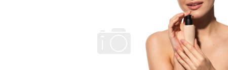 cropped view of young woman holding bottle with liquid makeup foundation isolated on white, banner 