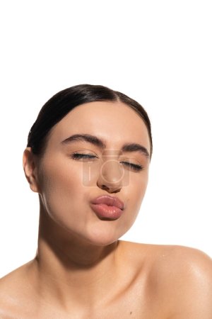 Foto de Morena joven con impecable maquillaje natural pucheros labios aislados en blanco - Imagen libre de derechos