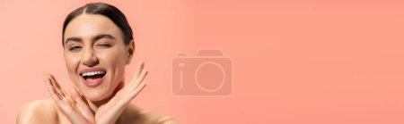 Photo for Excited young woman winking and gesturing isolated on pink, banner - Royalty Free Image