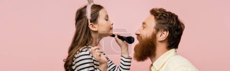 Photo for Preteen kid in headband holding makeup brush near bearded dad isolated on pink, banner - Royalty Free Image