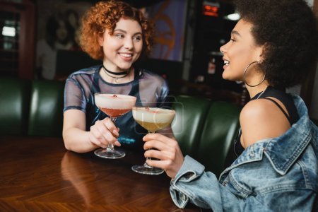 Fröhliche interrassische Freunde halten Kleeblatt-Club und Pisco Sour Cocktails in der Bar 