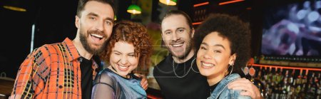 Cheerful multiethnic people looking at camera while spending time in bar, banner 