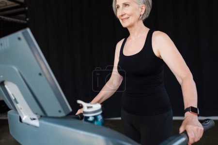 positive senior woman with grey hair working out on treadmill in gym   Stickers 648884828