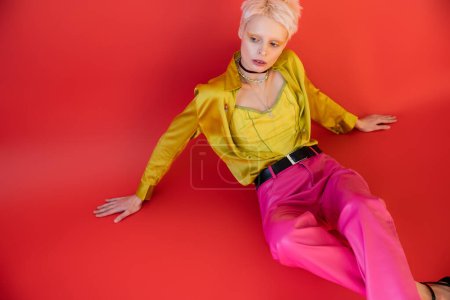 Photo for High angle view of young albino model in trendy clothes posing on carmine pink - Royalty Free Image