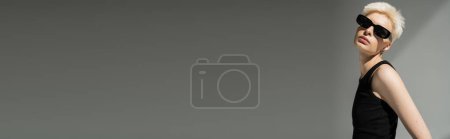 Téléchargez les photos : Élégante femme blonde en débardeur et lunettes de soleil noires sur fond gris, bannière - en image libre de droit