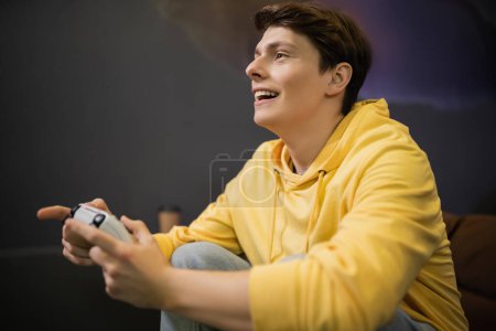 Photo for KYIV, UKRAINE - FEBRUARY 13, 2023: Cheerful young man playing video game in cyber club - Royalty Free Image