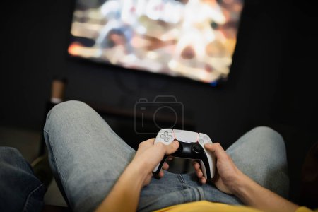 Photo for KYIV, UKRAINE - FEBRUARY 13, 2023: Cropped view of young man holding joystick in gaming club - Royalty Free Image