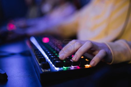 Ausgeschnittene Ansicht des Spielers mittels Tastatur mit Beleuchtung im Cyber-Club 