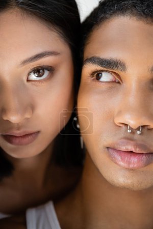 close up portrait of cropped asian woman and african american man with silver piercing 