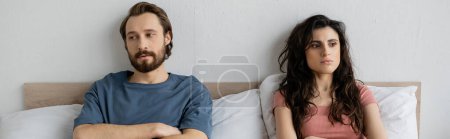 Téléchargez les photos : Couple mécontent avec des difficultés relationnelles assis sur le lit à la maison, bannière - en image libre de droit
