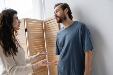 Angry woman talking to boyfriend during relationship crisis at home 