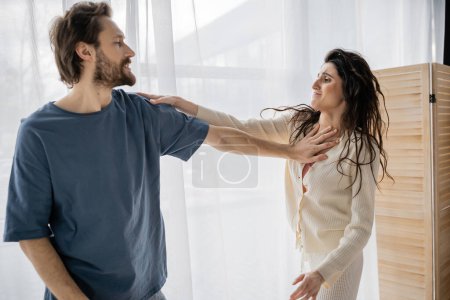 Bearded man pushing scared girlfriend during quarrel at home 