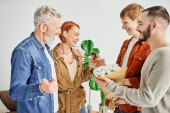 joyful gay couple giving flowers and wine bottle while visiting happy parents at home t-shirt #653456778