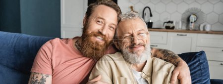Smiling gay man hugging mature partner at home, banner 