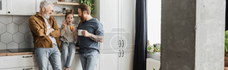Téléchargez les photos : Parents de même sexe avec café regardant fille avec croissant parler dans la cuisine, bannière - en image libre de droit