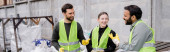 Cheerful multiethnic sorters in high visibility vests and gloves talking while standing near trash in outdoor waste disposal station, garbage sorting and recycling concept, banner  Stickers #658271632