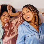 Excited and joyful multiethnic girlfriends in colorful pajama dancing and having fun together during pajama party at home, bonding time in comfortable sleepwear, banner 