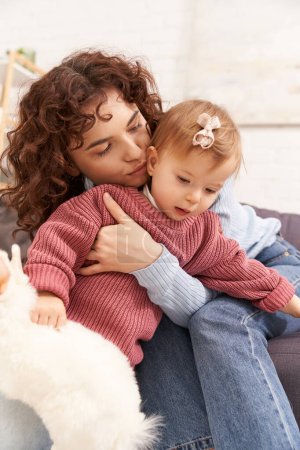 Einbeziehung mit Kind, glückliche Frau küsst Kleinkind Tochter im gemütlichen Wohnzimmer, spielen mit Kaninchen, Qualitätszeit, lässige Kleidung, Bindung zwischen Mutter und Kind, Stofftier 